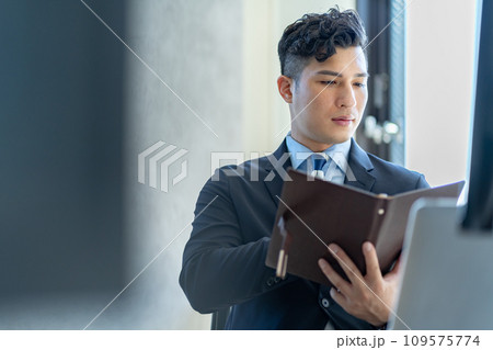 デスクワークをする男性ビジネスマン デスクワークをする男性ビジネスマン 109575774