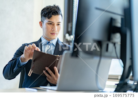 デスクワークをする男性ビジネスマン デスクワークをする男性ビジネスマン 109575775