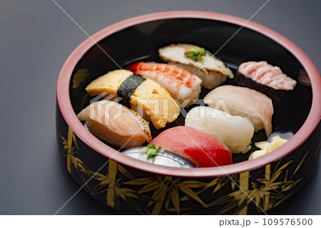 漆塗りの木桶に入った美味しそうな寿司 109576500