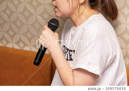 マイクを持ってカラオケを楽しむ女性 マイクを持ってカラオケを楽しむ女性 109578838