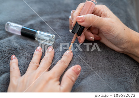 Asian woman's hands painting nails Beauty at your fingertips Asian woman's hands painting nails Beauty at your fingertips 109582072