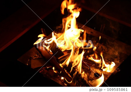 焚き火台でメラメラと燃える薪の炎 109585861