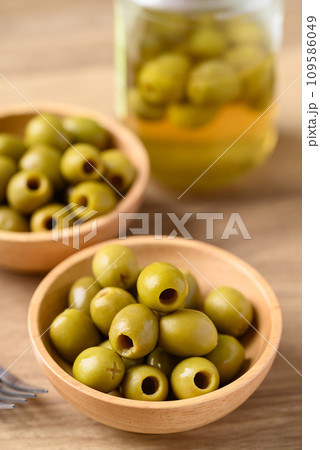 Pickled olives, Pitted green olives in wooden bowl 109586049