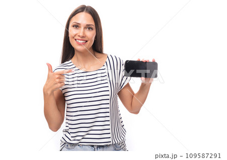 30 year old pretty brunette model woman with long straight hair dressed in a striped t-shirt shows a 109587291