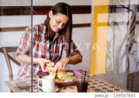 Caucasian woman in casual clothes having lunch in cafe. Caucasian woman in casual clothes having lunch in cafe. 109587693