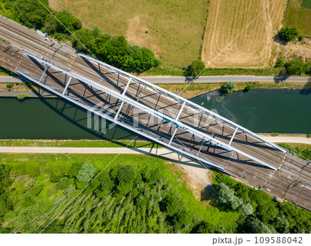 Crossing Paths: Aerial View of a Railway Bridge Over a Canal 109588042