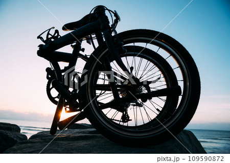 A folding bike on sunrise seaside road A folding bike on sunrise seaside road 109590872
