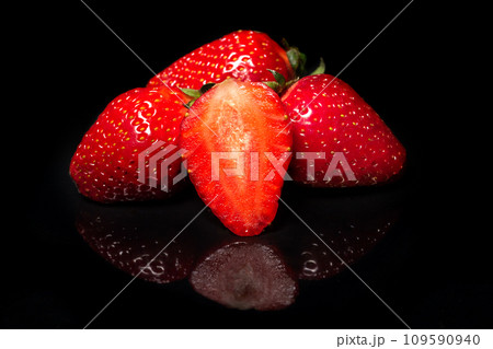 Ripe red strawberry on a black background with reflection 109590940