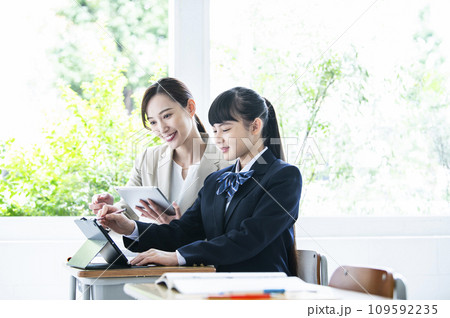 タブレットPCで勉強する女子中学生と女性教員 タブレットPCで勉強する女子中学生と女性教員 109592235