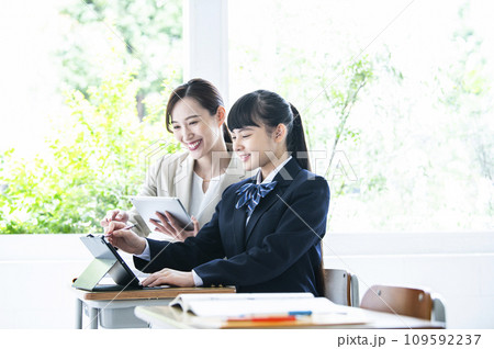 タブレットPCで勉強する女子中学生と女性教員 109592237