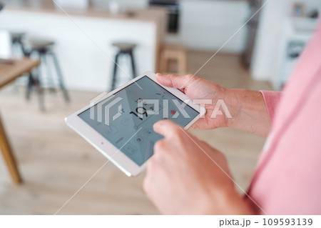 Man using smart thermostat, adjusting, lowering heating temperature at home. Concept of sustainable, efficient, and smart technology in home heating and thermostats. 109593139