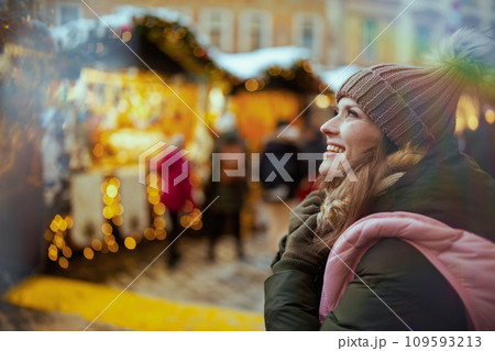 happy woman at christmas fair in city looking into distance happy woman at christmas fair in city looking into distance 109593213