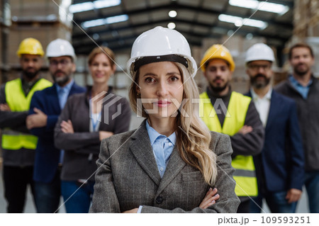 Full team of warehouse employees standing in warehouse. Team of workers, managers, female director in modern industrial factory, heavy industry, manufactrury. 109593251