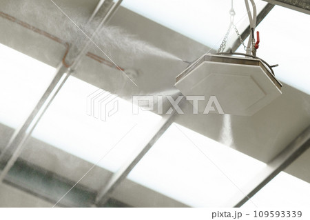 Industrial dust control system in modern manufacturing factory. Dust suppression with water mist, creating fine water mist, moistening dust particles. Industrial dust control system in modern manufacturing factory. Dust suppression with water mist, creating fine water mist, moistening dust particles. 109593339