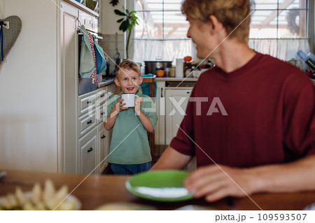 Father and son eating breakfast together in home kitchen. Healthy breakfast or snack before kindergarden. 109593507