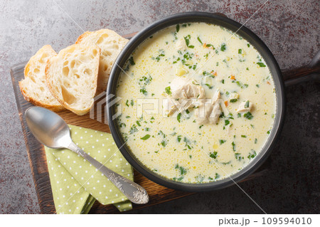 Homemade sour chicken soup with sour cream and vegetables closeup in a bowl. Horizontal top view 109594010