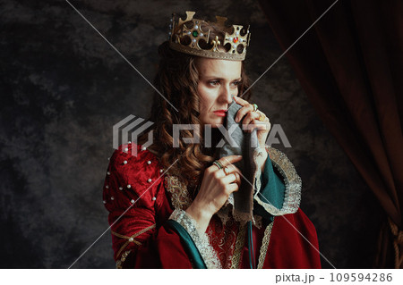 sad medieval queen in red dress with handkerchief crying sad medieval queen in red dress with handkerchief crying 109594286