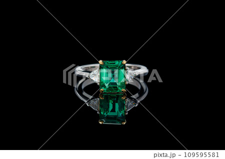 beautiful ring made of gold with precious stones emerald and diamonds on a black background 109595581
