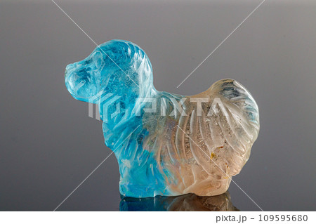 beautiful statuette of a dog from the mineral topaz on a gray background 109595680