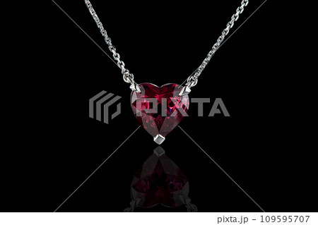 beautiful pendant with garnet with a gold chain on a black background 109595707
