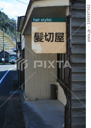 レトロな理髪店の看板と路線バス 109597302