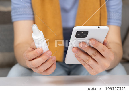 Woman reading instructions for the use of medication on the Internet using a smartphone. Online appointment with a doctor. 109597595