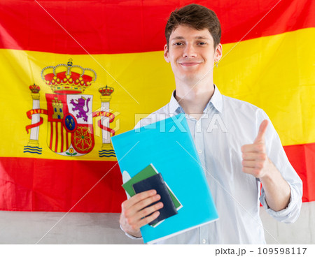 Positive student on background of flag of Spain - concept of studying abroad and immigration 109598117