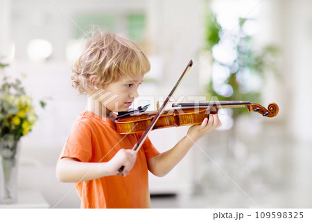 Child playing violin. Remote learning. 109598325