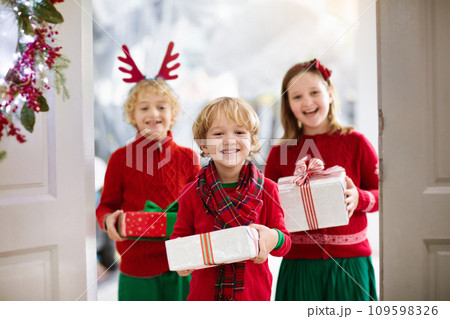 Family on Christmas day. Kids with gifts at door. 109598326