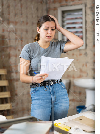 Portrait of frustrated woman designer standing in apartment Portrait of frustrated woman designer standing in apartment 109598895