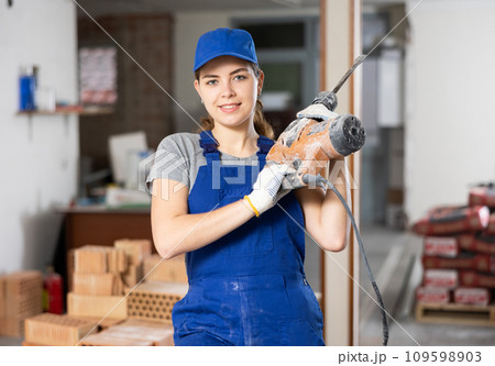 Portrait of woman engineer holding electric hammer 109598903