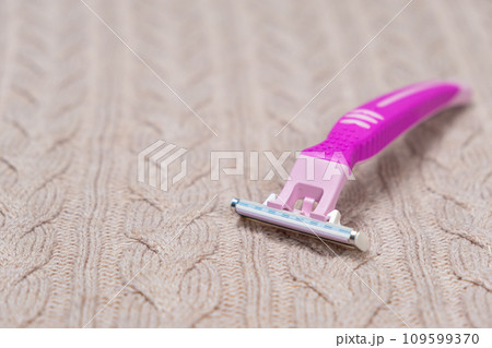 Razor on sweater. Removing pills from clothing Razor on sweater. Removing pills from clothing 109599370
