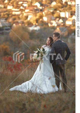 beautiful wedding couple together standing outdoor on natural background 109600004
