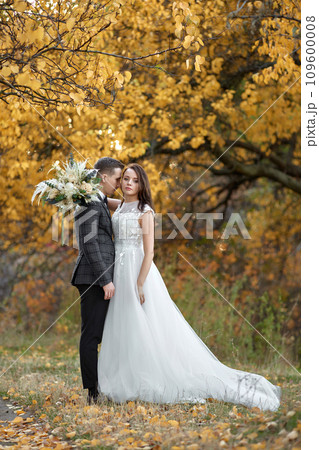 beautiful sensual bride in white wedding dress and groom standing outdoor on natural background 109600008