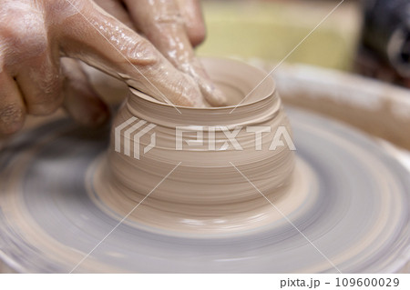 male hands making ceramic cup on pottery wheel, Close-up male hands making ceramic cup on pottery wheel, Close-up 109600029