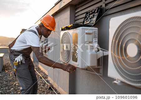 Male holding tablet and installing cooling system outdoors 109601096