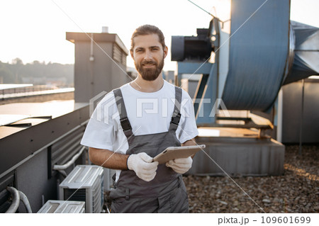 Construction man using tablet while working on rooftop 109601699