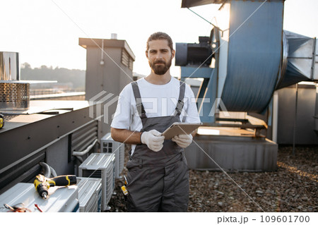 Construction man using tablet while working on rooftop 109601700