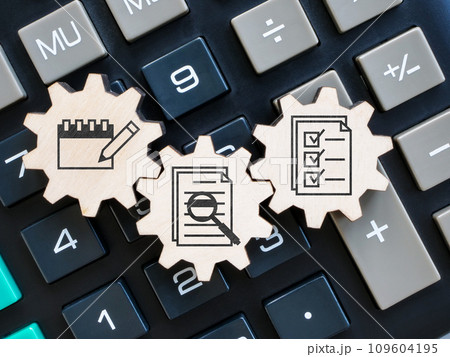Accounting and auditing. Gear wheels with document signs on a calculator. 109604195