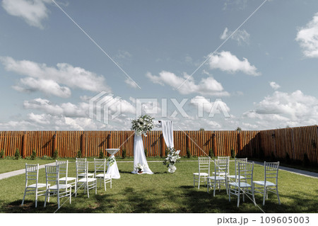 Outdoor wedding venue with chairs and arch 109605003