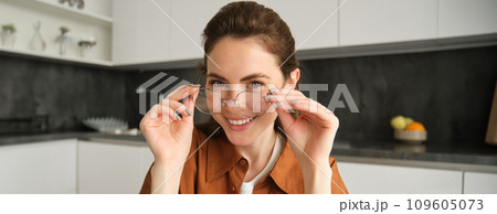 Close up portrait of beautiful brunette woman at home, smiling, wearing her glasses and laughing Close up portrait of beautiful brunette woman at home, smiling, wearing her glasses and laughing 109605073