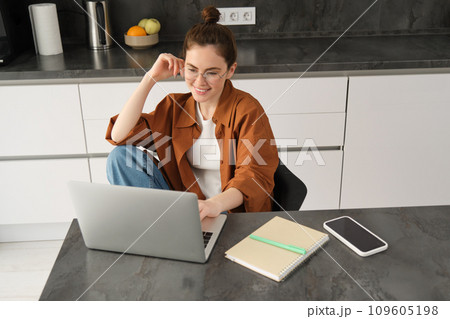 Top view of young student, woman in glasses, sitting at home with laptop, studying, doing homework or joining online course lesson from computer 109605198