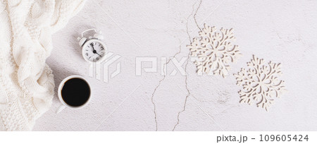 Winter web banner, coffee, alarm clock, sweater and snowflakes on light, top view 109605424