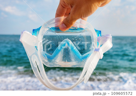mask for swimming underwater in hand. Accessories for diving in the sea. Concept of necessary things for a holiday at sea mask for swimming underwater in hand. Accessories for diving in the sea. Concept of necessary things for a holiday at sea 109605572