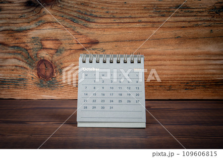 OCTOBER 2024 cardboard desk calendar on a wooden texture background 109606815