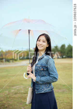 雨の中で公園で傘をさして散歩をする女性 雨の中で公園で傘をさして散歩をする女性 109607628