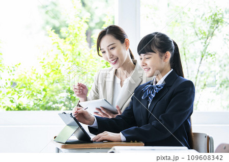 タブレットPCで勉強する女子中学生と女性教員 タブレットPCで勉強する女子中学生と女性教員 109608342
