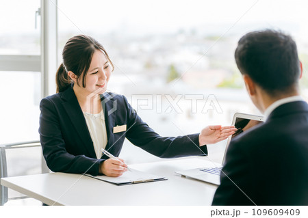 パソコンを使って商談・商品説明するビジネスウーマン（不動産・プラン） 109609409