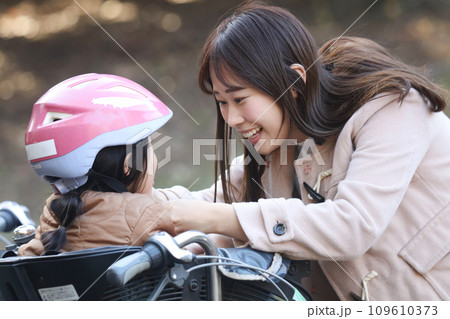 子供にヘルメットを装着する母親 109610373