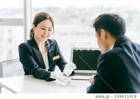 腕時計を質屋・リサイクルショップに買取査定に出すビジネスマンと鑑定士・査定士の女性 腕時計を質屋・リサイクルショップに買取査定に出すビジネスマンと鑑定士・査定士の女性 109611429